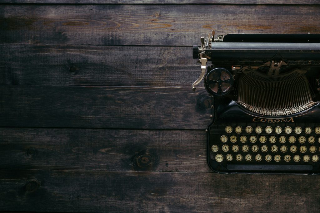 Vintage typewriter sits on wood table
